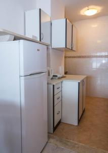 a kitchen with a white refrigerator and cabinets at Holiday Home Ratac Sunshine Beach in Slano +34 photos