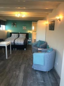 ein Wohnzimmer mit einem Sofa und einem Bett in der Unterkunft Mikasabeach in Zandvoort