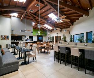 un restaurante con bar, mesas y sillas en Holiday Inn Hotel & Suites Chihuahua, an IHG Hotel en Chihuahua