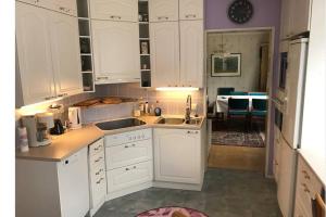 eine weiße Küche mit weißen Schränken und ein Esszimmer in der Unterkunft Cosy 4 Big r+sauna house near communication+market in Vantaa + 7 Fotos