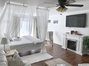 um quarto com uma cama, uma ventoinha de tecto e uma lareira em Romantic Studio Cottage em Lambton Shores