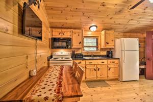 a kitchen with wooden cabinets and a white refrigerator at Hooah Cabin Retreat with Grill and Step-Free Access in Parsons