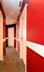 a hallway with red walls and a white door at Hotel The Moon in Brussels