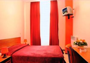 una camera con letto rosso e una finestra con tende rosse di Hotel The Moon a Bruxelles