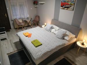 um quarto com uma cama com dois itens em Fehérló Vendégház & Restaurant em Bük