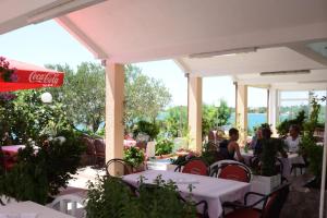 a group of people sitting at tables on a patio at Pansion Croatia in Starigrad