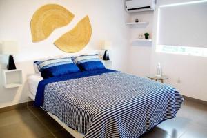 a bedroom with a bed with blue and white sheets at Departamento Las Palmeras de Bocapán 201 in Zorritos +25 photos