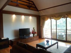 sala de estar con sofá y TV en Prestige Vacation Apartments - Hanbi Mansions en Baguio