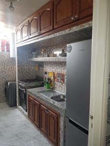 La cuisine est équipée d'un évier et d'un réfrigérateur. dans l'établissement Residence Bassatine, à Temara