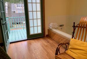 a bathroom with a bath tub and a rocking chair at Gordon Beach Inn in Union Pier