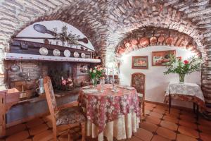 a dining room with a table and a stone wall at L'Auberge du Choucas in Le Monêtier-les-Bains