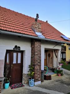 uma pequena casa de tijolos com telhado vermelho em smještaj Mala Zidanica em Tomaševci