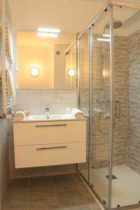 ein Bad mit einem Waschbecken und einer Dusche in der Unterkunft Hôtel Alexandra in Roquebrune-Cap-Martin