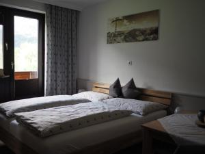 a bedroom with two twin beds and a window at Gästehaus Hechenblaikner in Maurach