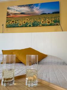 due bicchieri su un tavolo con un dipinto sul muro di Affittacamere Le Grotte - Le Grotte Rooms & Apartments a Camerano