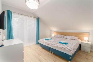 a bedroom with a bed and a large window at Plażowe Apartamenty Grzybowo in Grzybowo