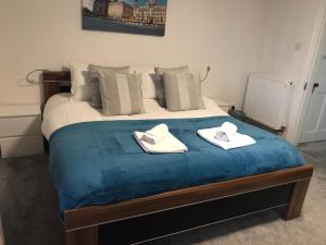a bedroom with a bed with two towels on it at The Windmill, 3 min drive to wicksteed park in Kettering