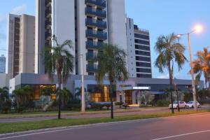 una calle con palmeras frente a un edificio en Hplus Premium Palmas en Palmas