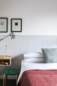 1 dormitorio con 1 cama con lámpara y taburete verde en The Stop, en Galway