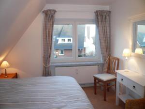 ヴェスターラントにあるHues-Loerki-App-2のベッドルーム1室(ベッド1台、窓、椅子付)