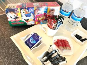 ダービーにあるGrand Central Apartmentsのお菓子、水、食品箱を用意したトレイ