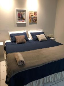 1 dormitorio con 1 cama grande con sábanas y almohadas azules en Flat no Executive Arrey Hotel en Teresina