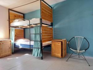 a room with two bunk beds and a chair at Bermejo Hostel in La Paz