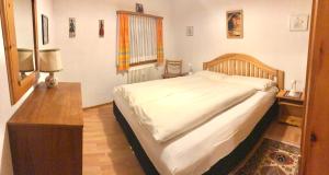 een slaapkamer met een groot bed en een tafel bij Chesa Panorama in Celerina