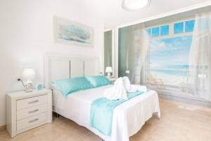 a white bedroom with a bed with a view of the ocean at Charming Villa in Competa with Private Pool in Cómpeta