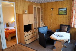 a hotel room with a bed and a desk and a chair at Ferienhaussiedlung am Chossewitzer See in Friedland