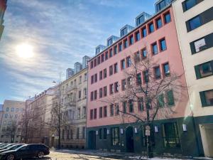 un edificio rosa al lado de una calle en Astoria Apartments, en Núremberg