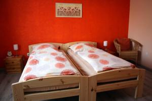 a wooden bed in a room with an orange wall at Haus Erika in Hemmoor