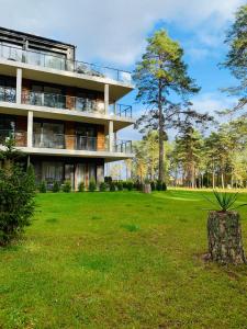 Um edifício com um toco de árvore à frente. em REMAR - Apartamenty nad Jeziorem Necko em Augustów