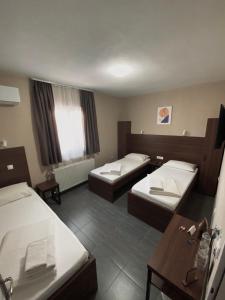 ein Hotelzimmer mit 2 Betten und einem Tisch in der Unterkunft Hotel Djerdan in Kraljevo