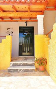 a black door on a house with a potted plant at TETRAKTYS estate in Ágios Matthaíos