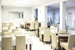 a dining room with white tables and chairs at Willa Koala in Karpacz