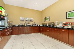 a large kitchen with wooden cabinets and appliances at Sleep Inn & Suites Devils Lake in Devils Lake