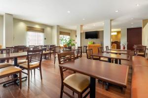 comedor con mesas y sillas de madera en Sleep Inn & Suites Devils Lake, en Devils Lake