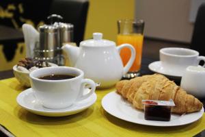 una mesa con una taza de café y un plato de comida en Shelter Hotel, en Kiev