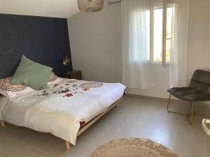Un dormitorio con una cama, una silla y una ventana en Sitio Nathalie et Jos, en Saint-Laurent-de-Carnols