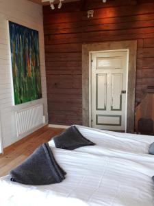 a large white bed in a room with a door at Pilgården Fornåsa, Drängstugan in Fornåsa