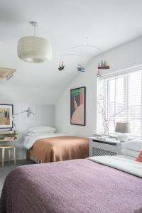 a white bedroom with two beds and a window at The Stop in Galway