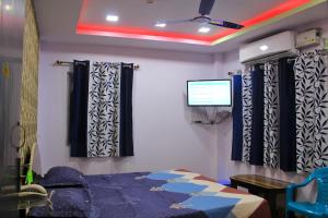 um quarto com uma cama e uma televisão na parede em PG Homes em Port Blair