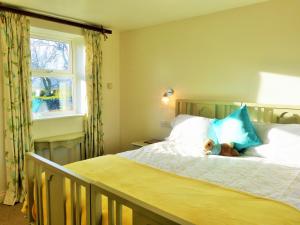 a bedroom with a bed with a teddy bear on it at Roman Cottage - - Hadrian's Wall dark sky outpost. in Newcastle upon Tyne