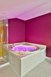 a purple bathroom with a tub in a room at Ghan Hotel in Istanbul