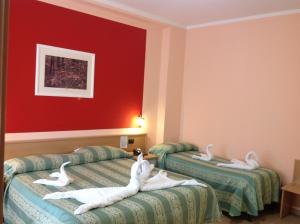 three swans laying on beds in a hotel room at Hotel La Pergola in San Giovanni a Piro