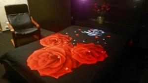 eine Gruppe roter Rosen auf einem Tisch mit einem Stuhl in der Unterkunft 4 Stars Magheru Studio in Bukarest