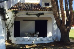 ein Gebäude mit einem Tisch und einem Stuhl auf einer Veranda in der Unterkunft cala serena beach 6 in Cala Serena