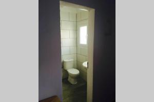 ein Badezimmer mit Toilette und Fenster in der Unterkunft cala serena beach 6 in Cala Serena + 13 Fotos