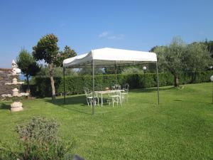 a table and chairs under a white canopy in a yard at B&B BOUTIQUE DI CHARME "ETNA-RELAX-NATURA" in Zafferana Etnea
